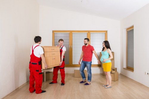 Movers packing fragile household items for transport